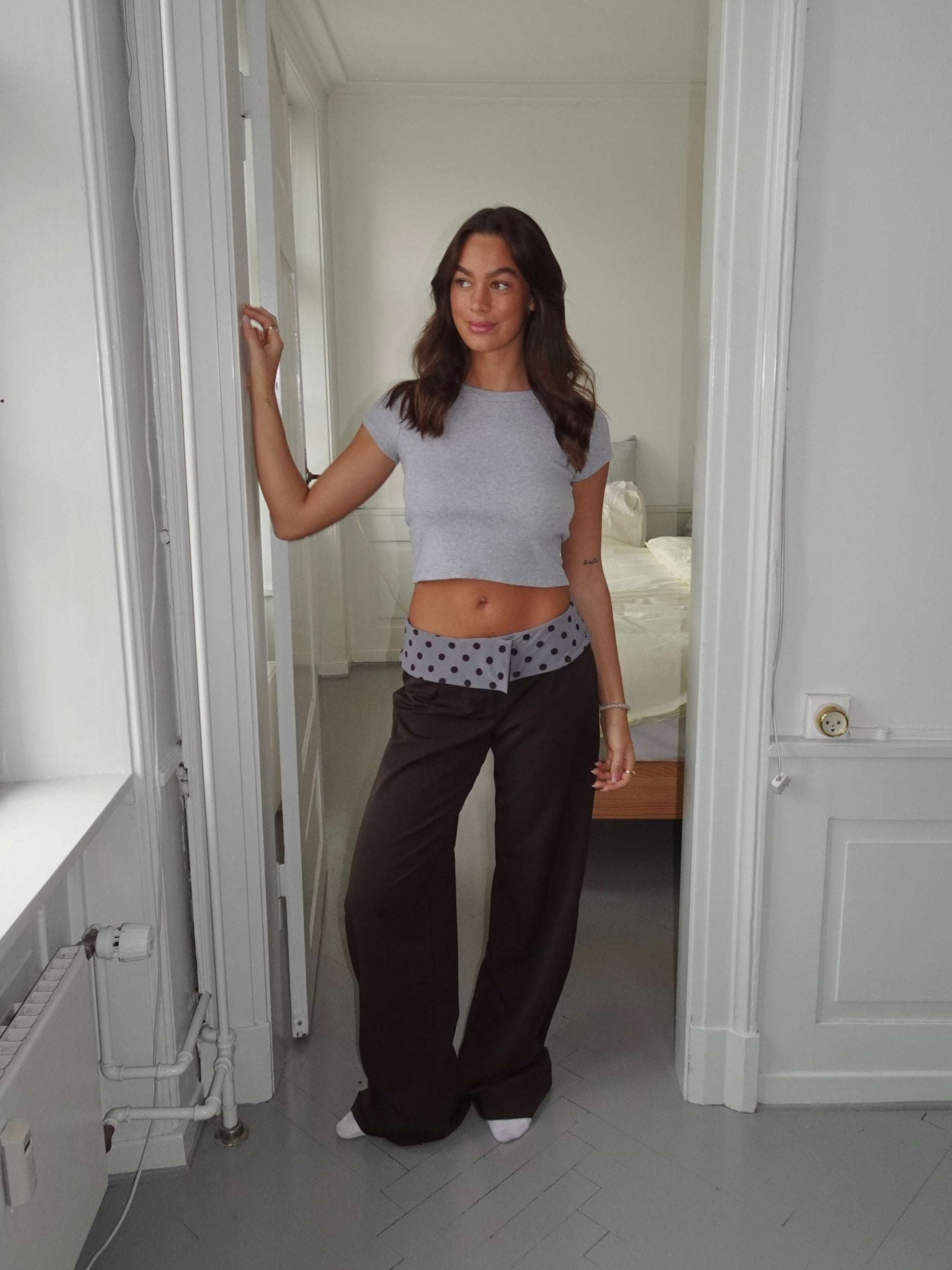 Black tailored pants with sage polka dot waistband, waist detail close-up