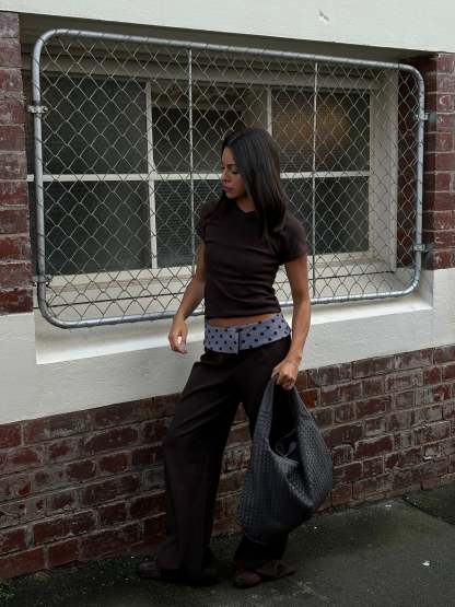 Black tailored pants with sage polka dot waistband, standing pose outdoor
