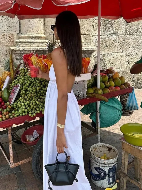 White sleeveless maxi dress with gathered skirt, showing completely open backless design