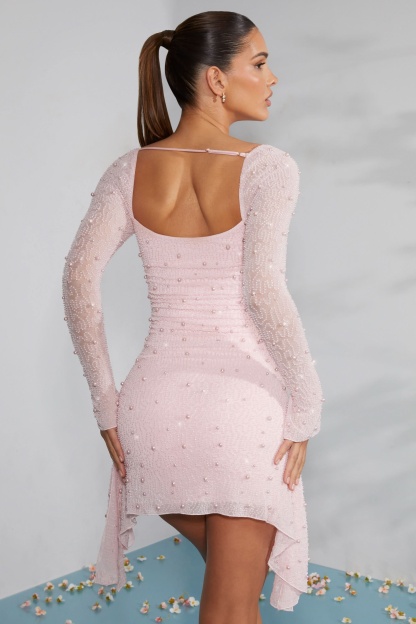 Back view of blush beaded mini dress with open scoop back and asymmetrical hem