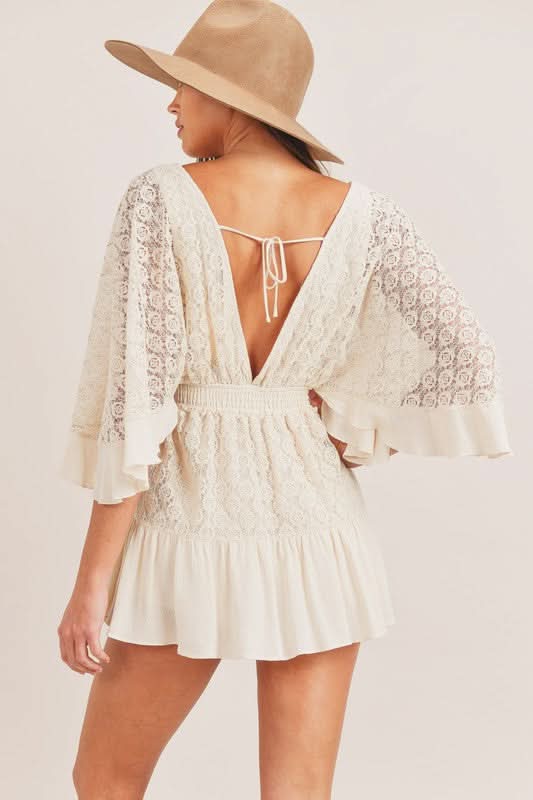 Back view of cream lace romper showing open back with tie closure