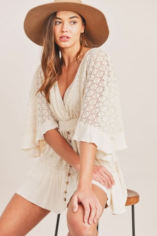 Cream lace romper with v-neckline and pleated skirt detail