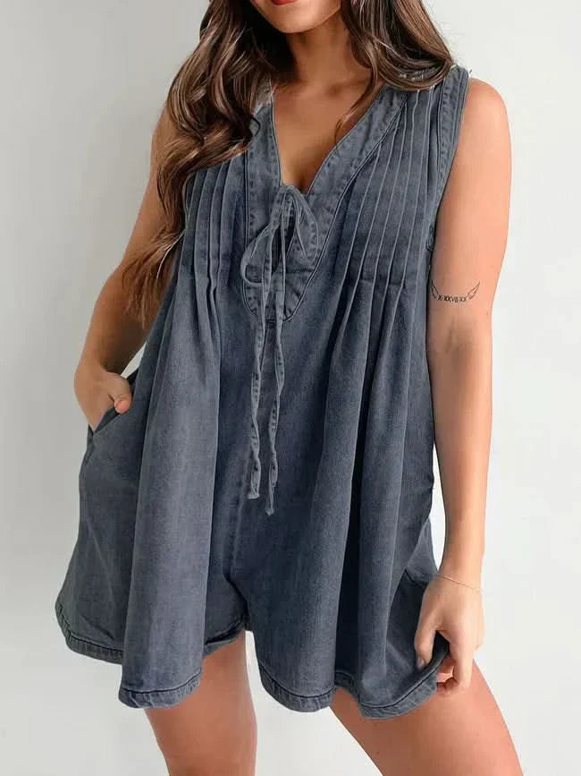 Blue denim lace-up romper with V-neckline and flowing pleated design