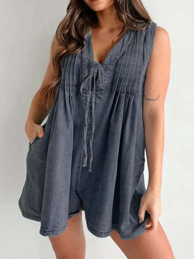 Blue denim lace-up romper with V-neckline and flowing pleated design