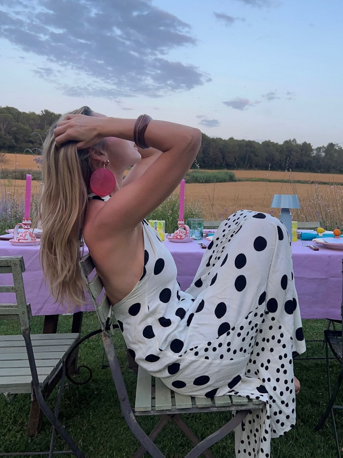 White maxi dress with black polka dots, backless design with flowing fabric