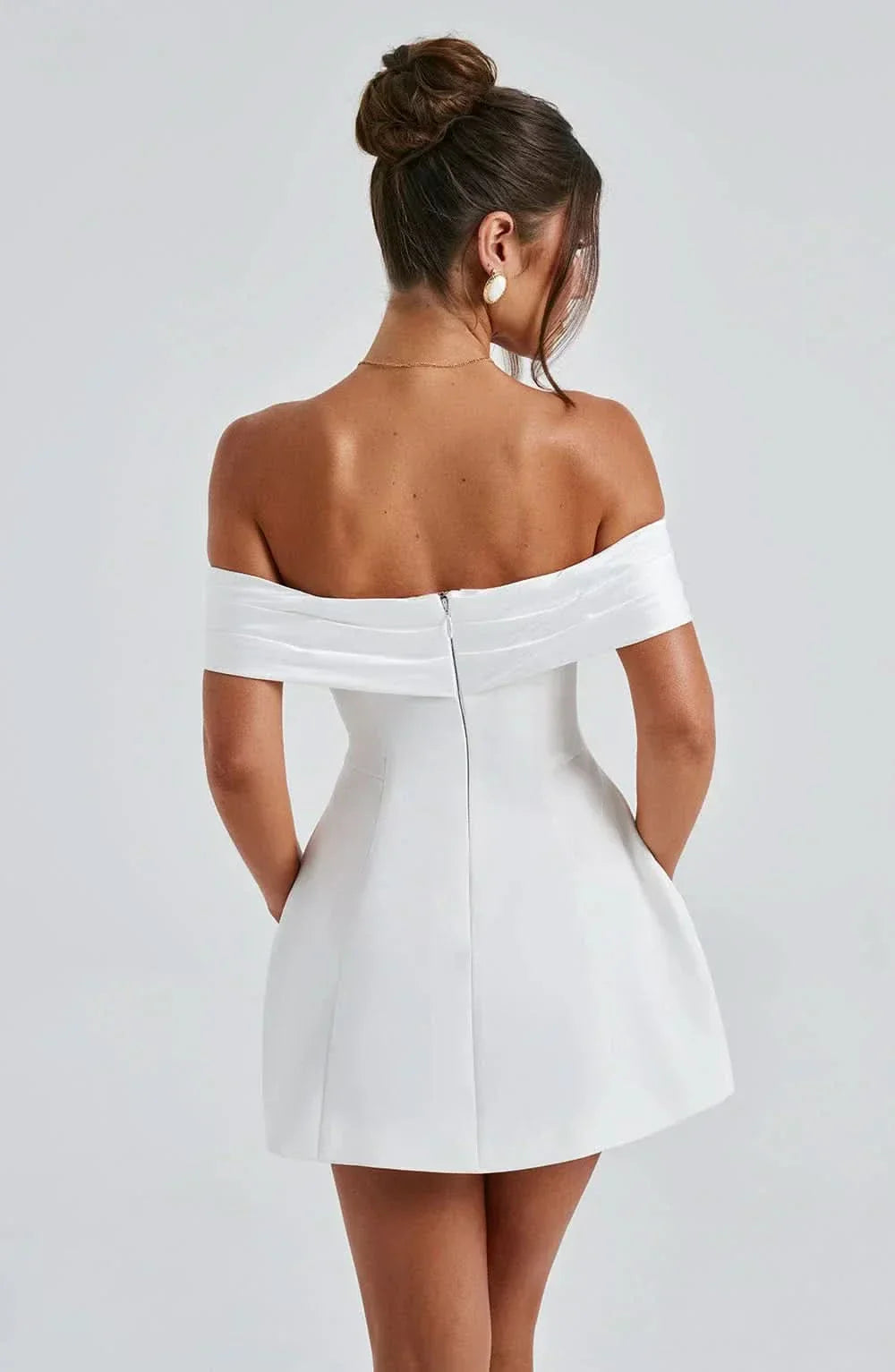 Rear detail of white mini dress showing center back zipper and off-shoulder neckline