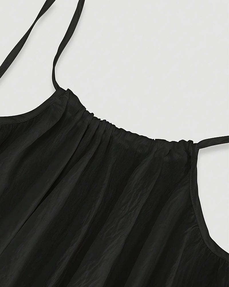 Close-up of black maxi dress neckline with pleated bodice detail