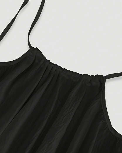 Close-up of black maxi dress neckline with pleated bodice detail