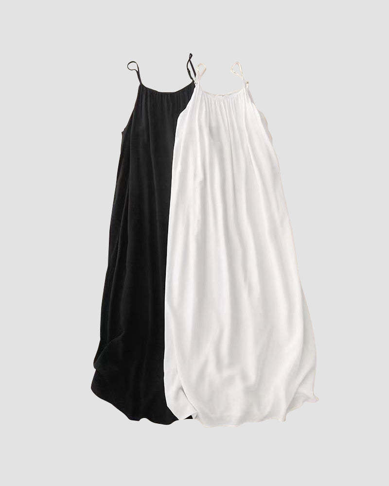 Black and white backless maxi dresses side by side on hangers