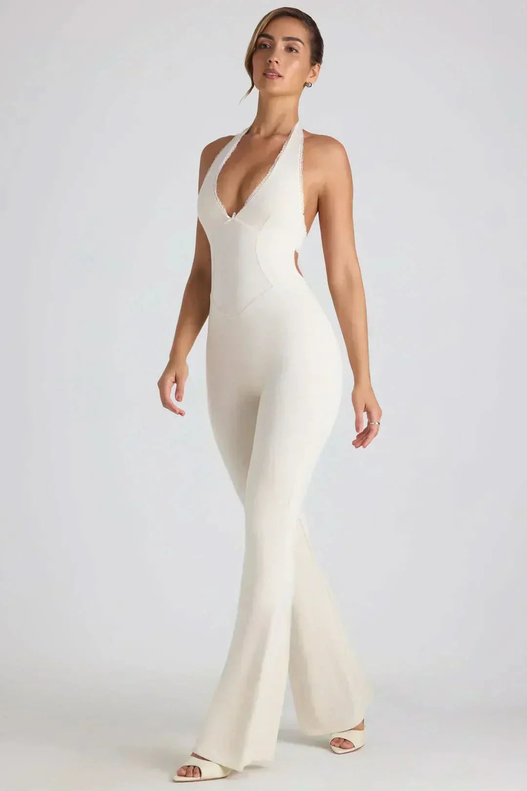 White halter backless maxi jumpsuit with deep V-neckline and flared legs