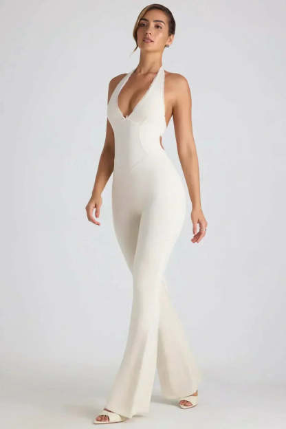 White halter backless maxi jumpsuit with deep V-neckline and flared legs