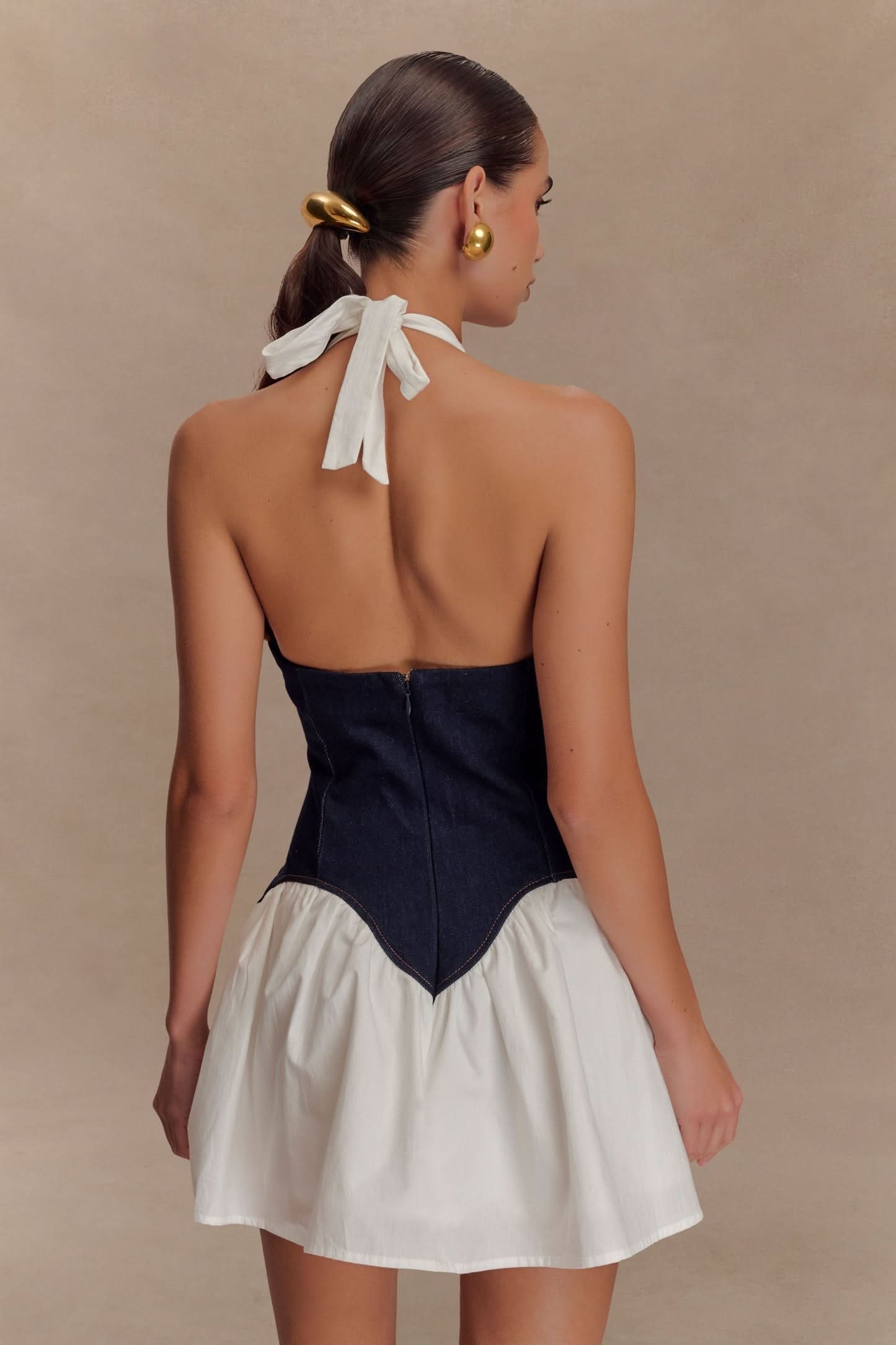 Back detail of navy denim corset with center seam and white tie closure