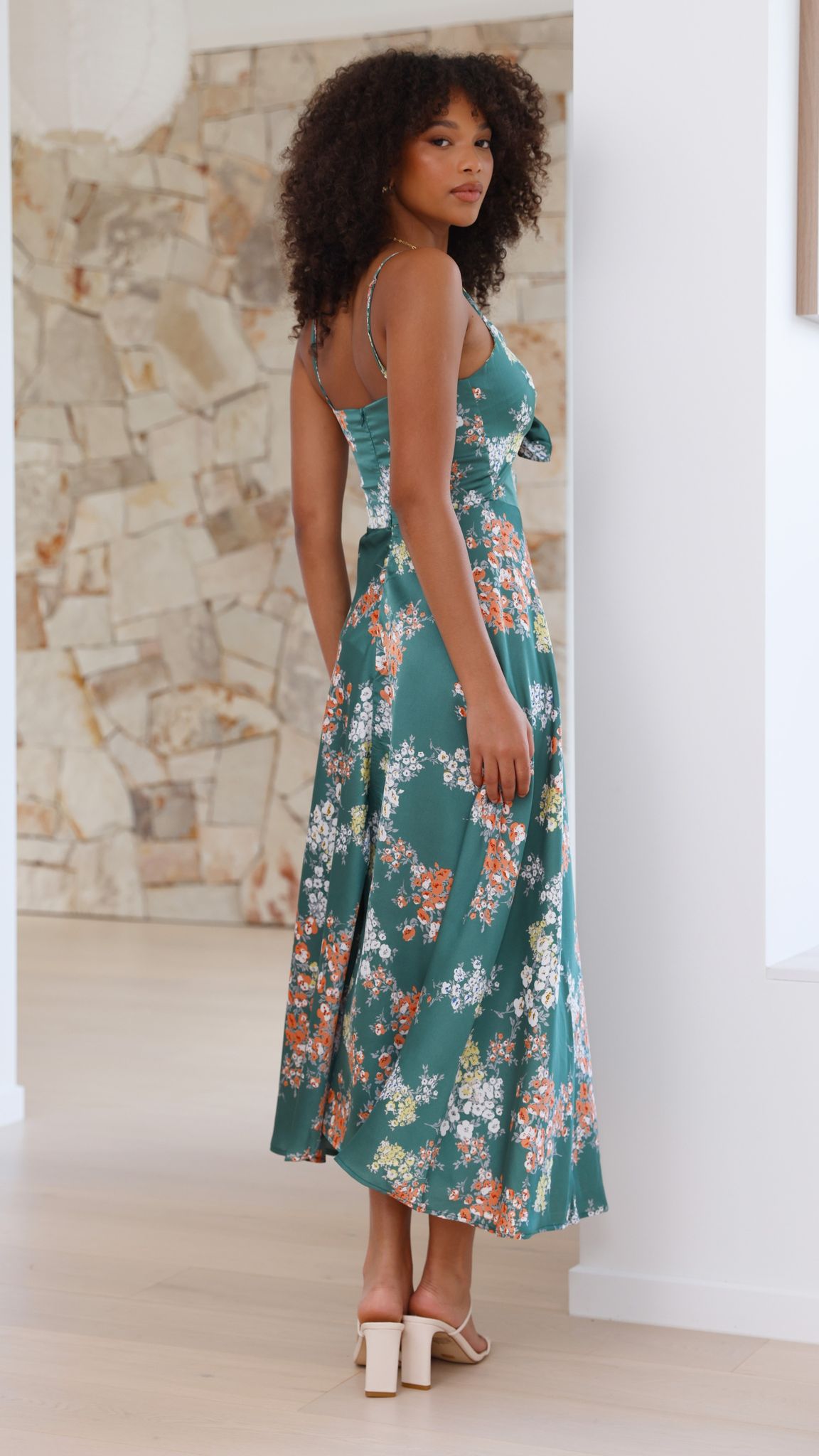 Back view of green floral midi dress with thin straps and cutout detail