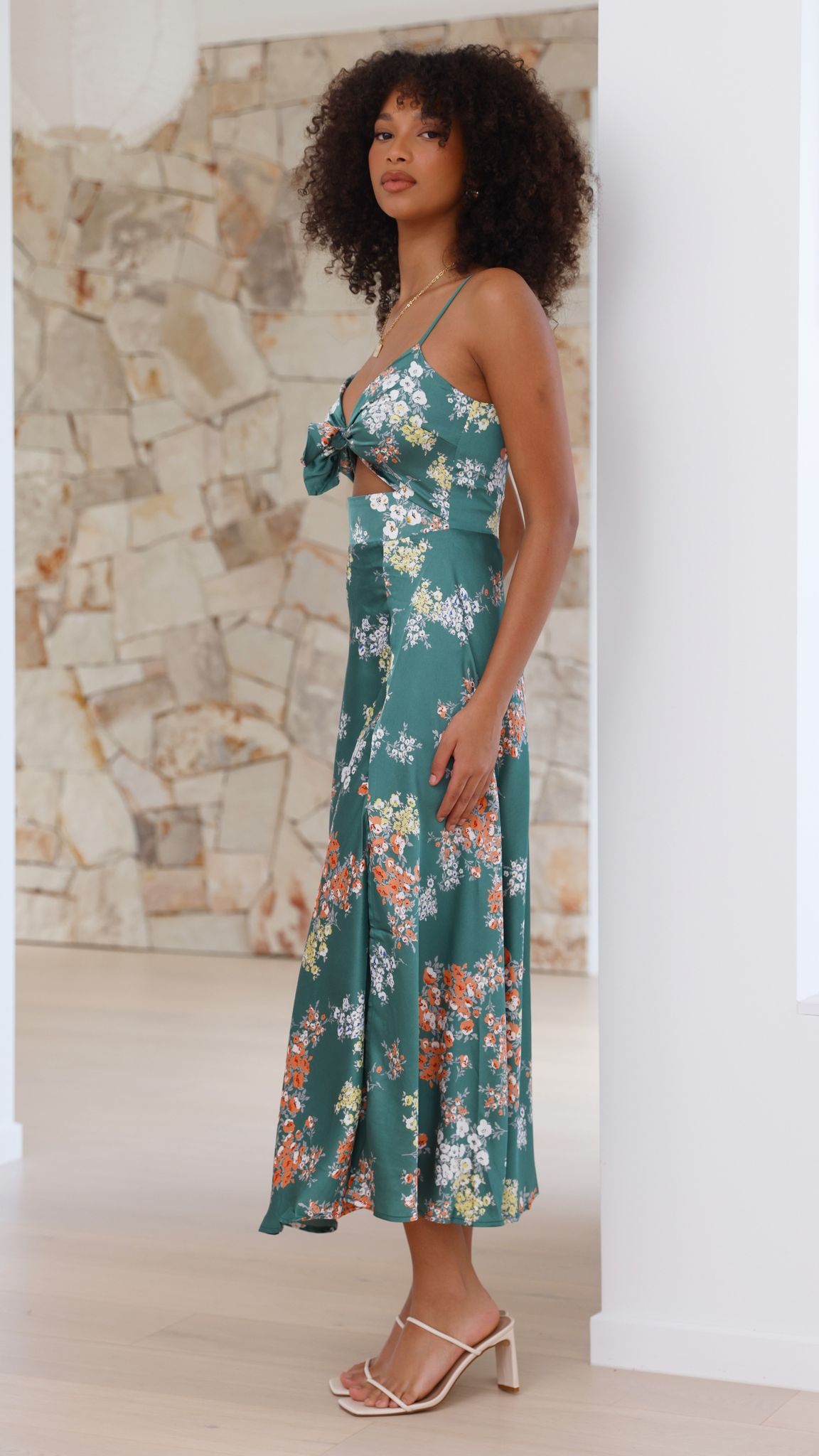 Side profile of green floral midi dress with front slit and cutout