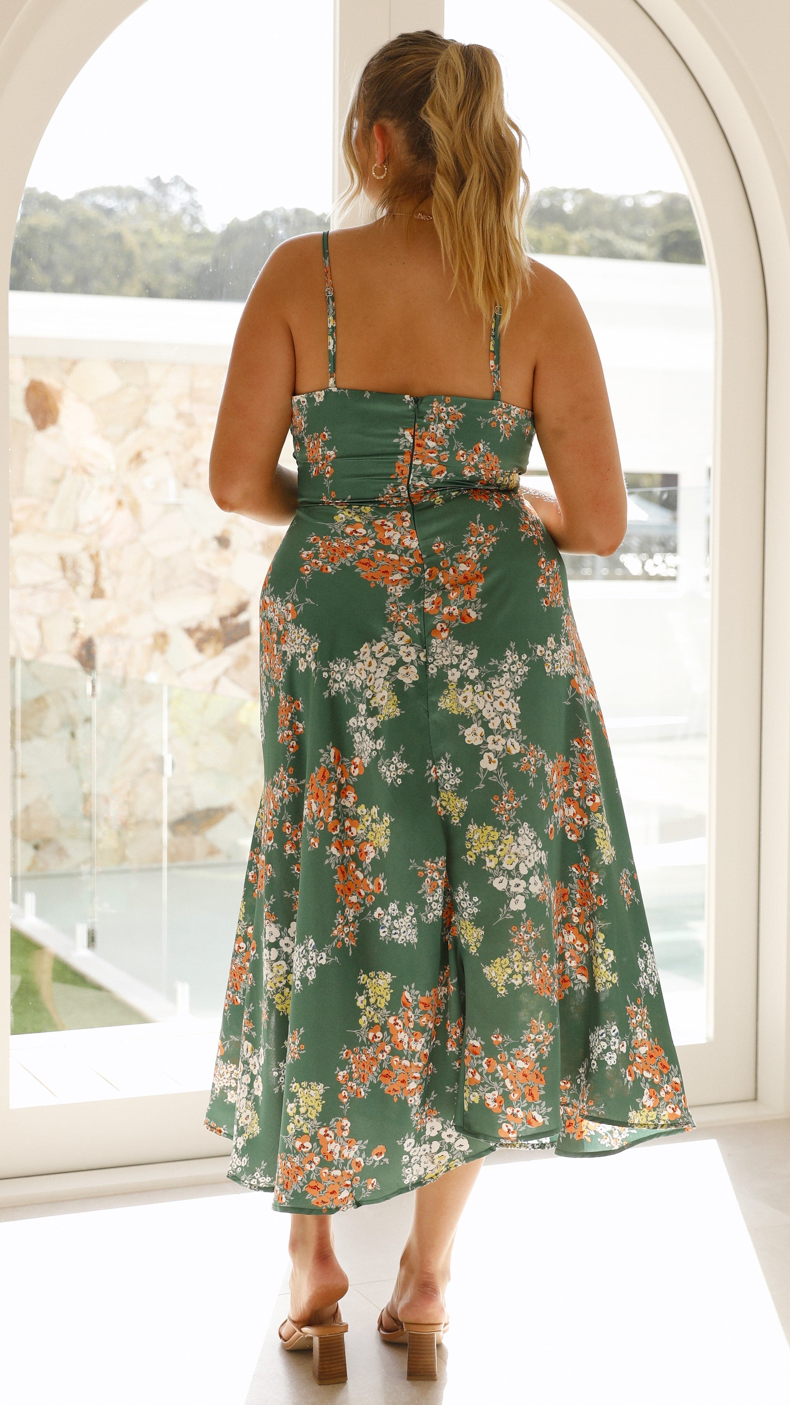 Back view of green floral midi dress showing cutout design