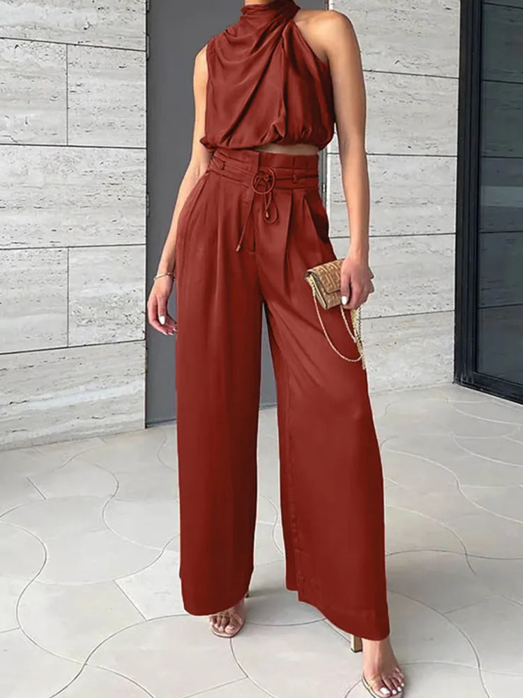 Rust red draped sleeveless top with high-waisted wide-leg pants and drawstring detail