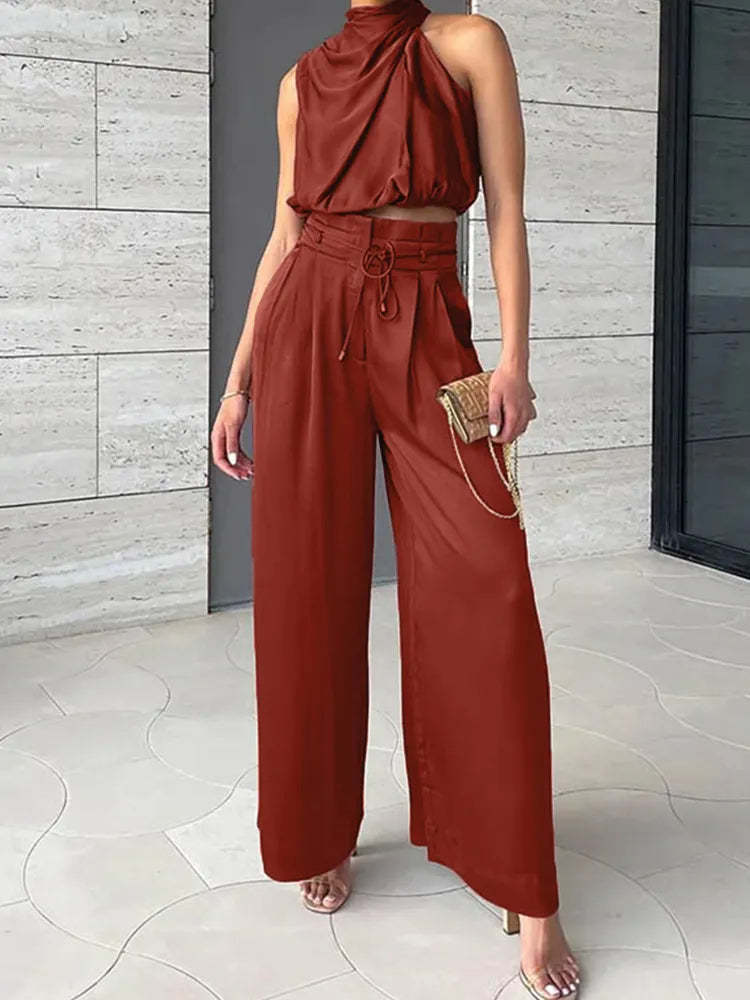 Rust red draped sleeveless top with high-waisted wide-leg pants and drawstring detail