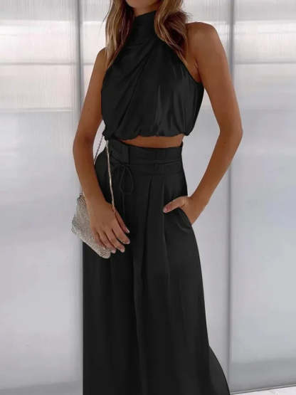 Black draped halter crop top with pleated high-waisted wide pants and tie waist