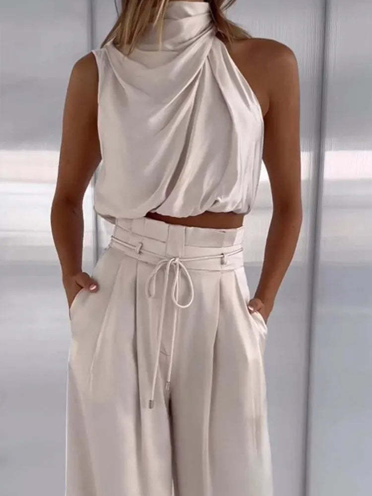 Front view of cream draped halter set showing gathered neckline and high-waisted pleated pants