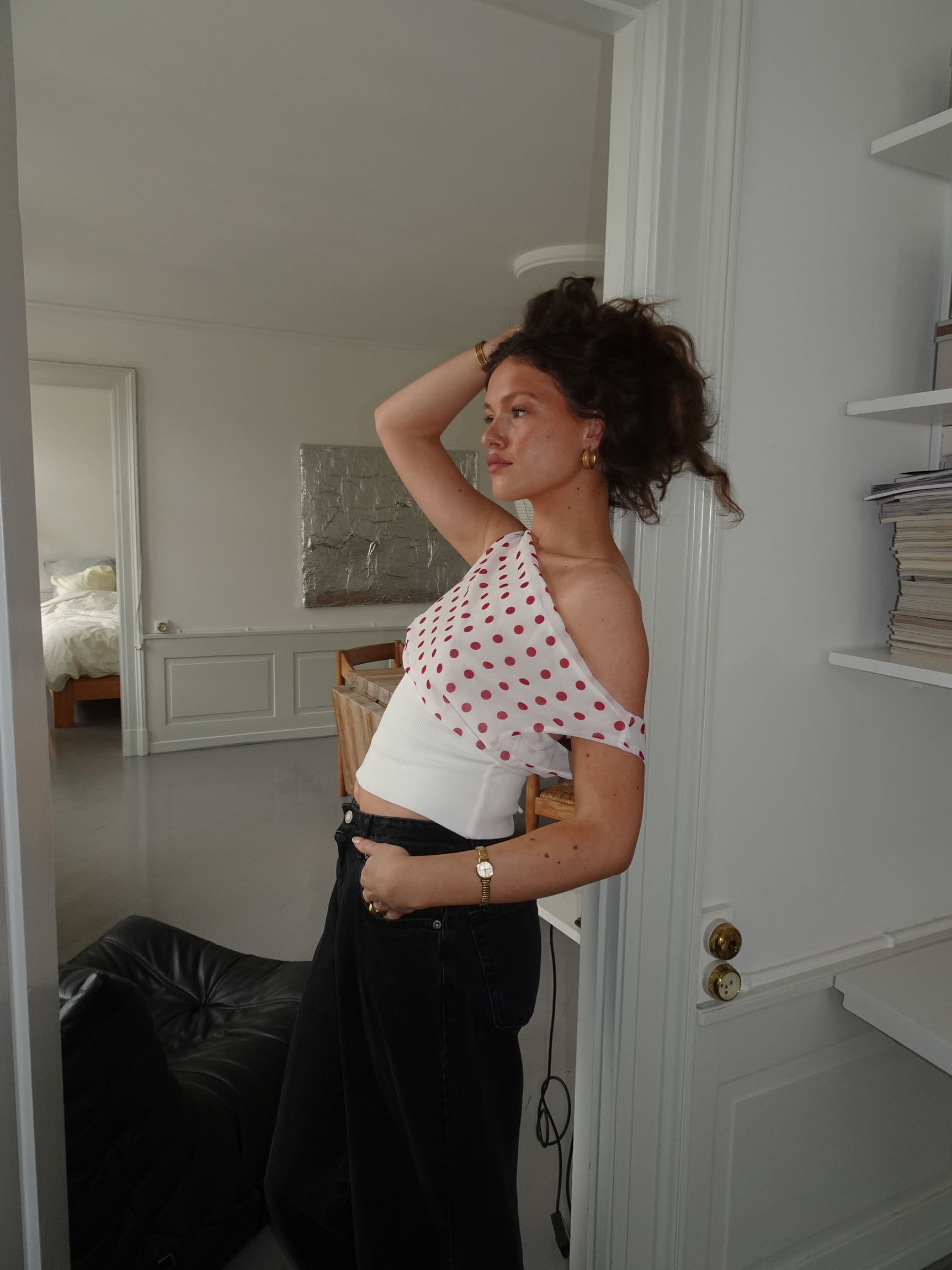 Red polka dot draped crop top with white ribbed band, side view