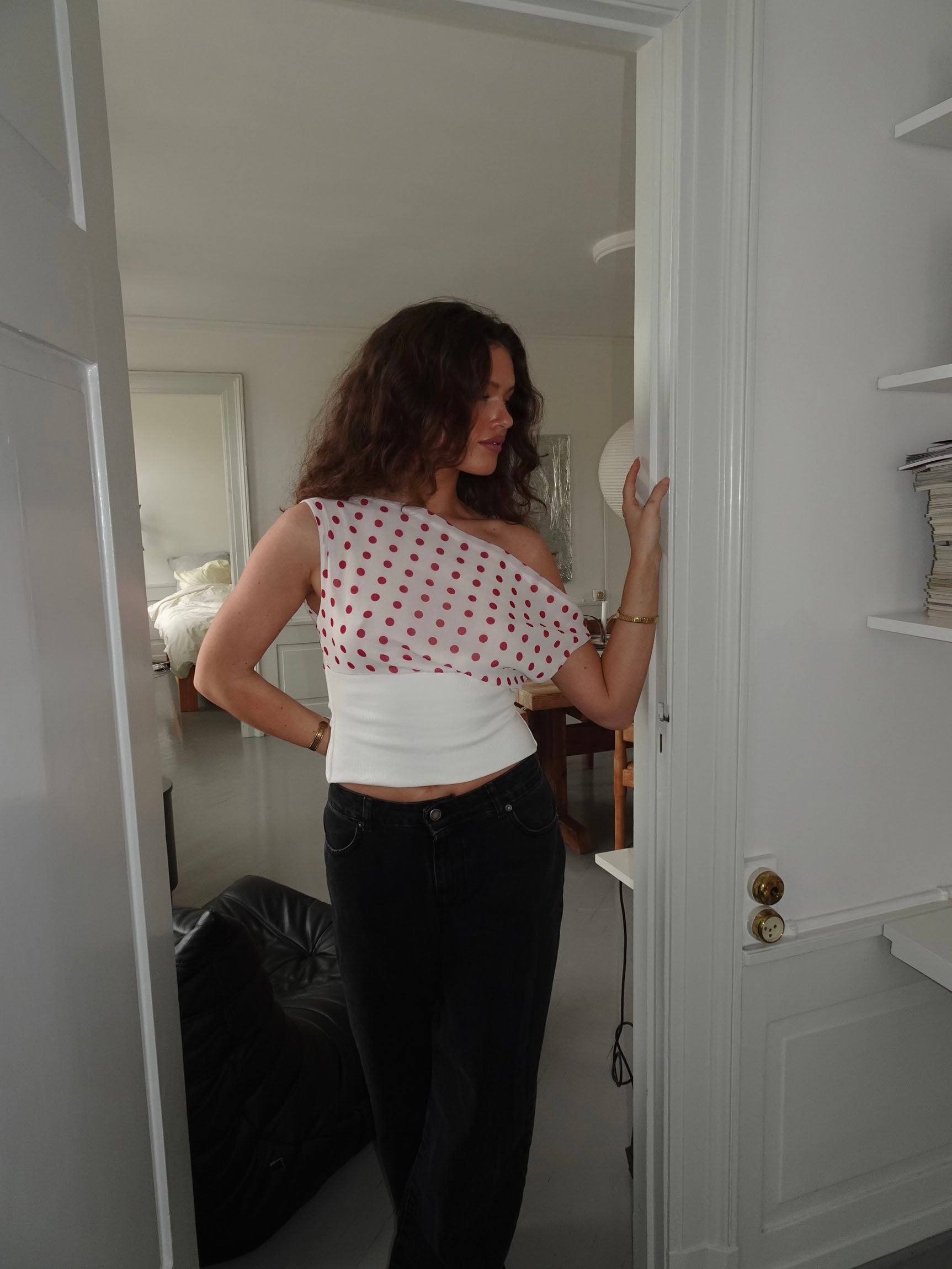 Back view of red polka dot draped crop top with white trim