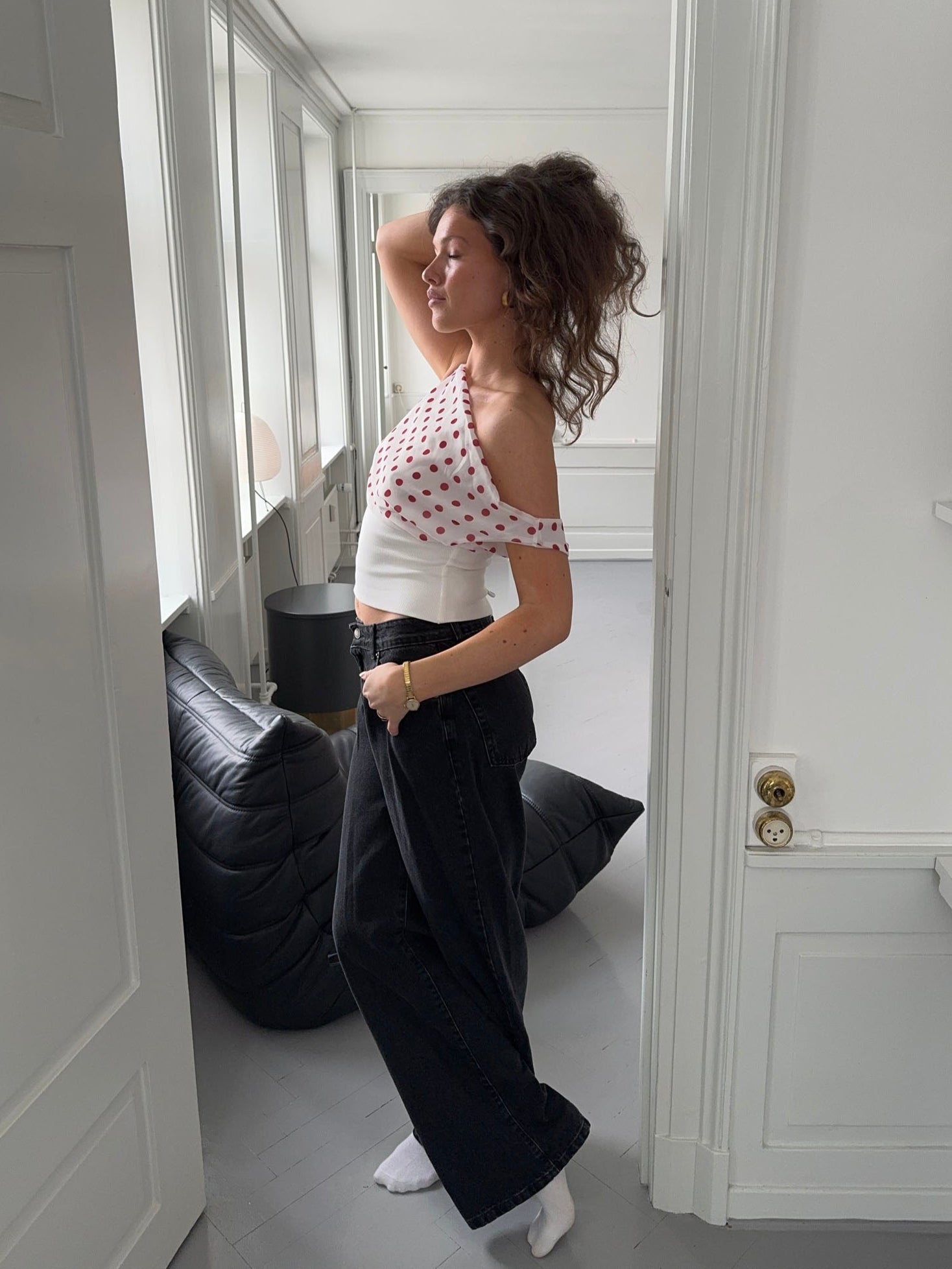 Side profile of draped polka dot crop top with white waistband