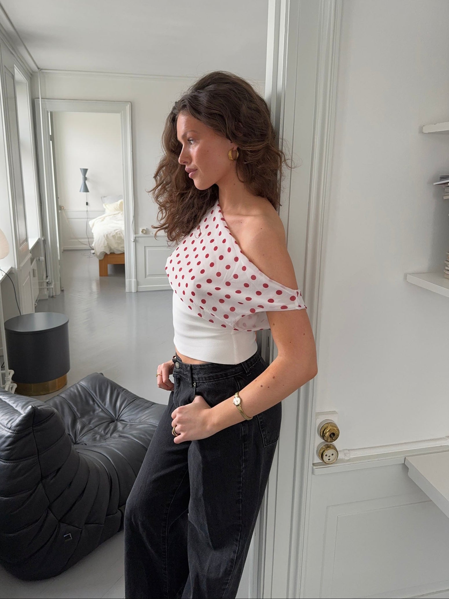 Red polka dot draped crop top with white ribbed band, side view
