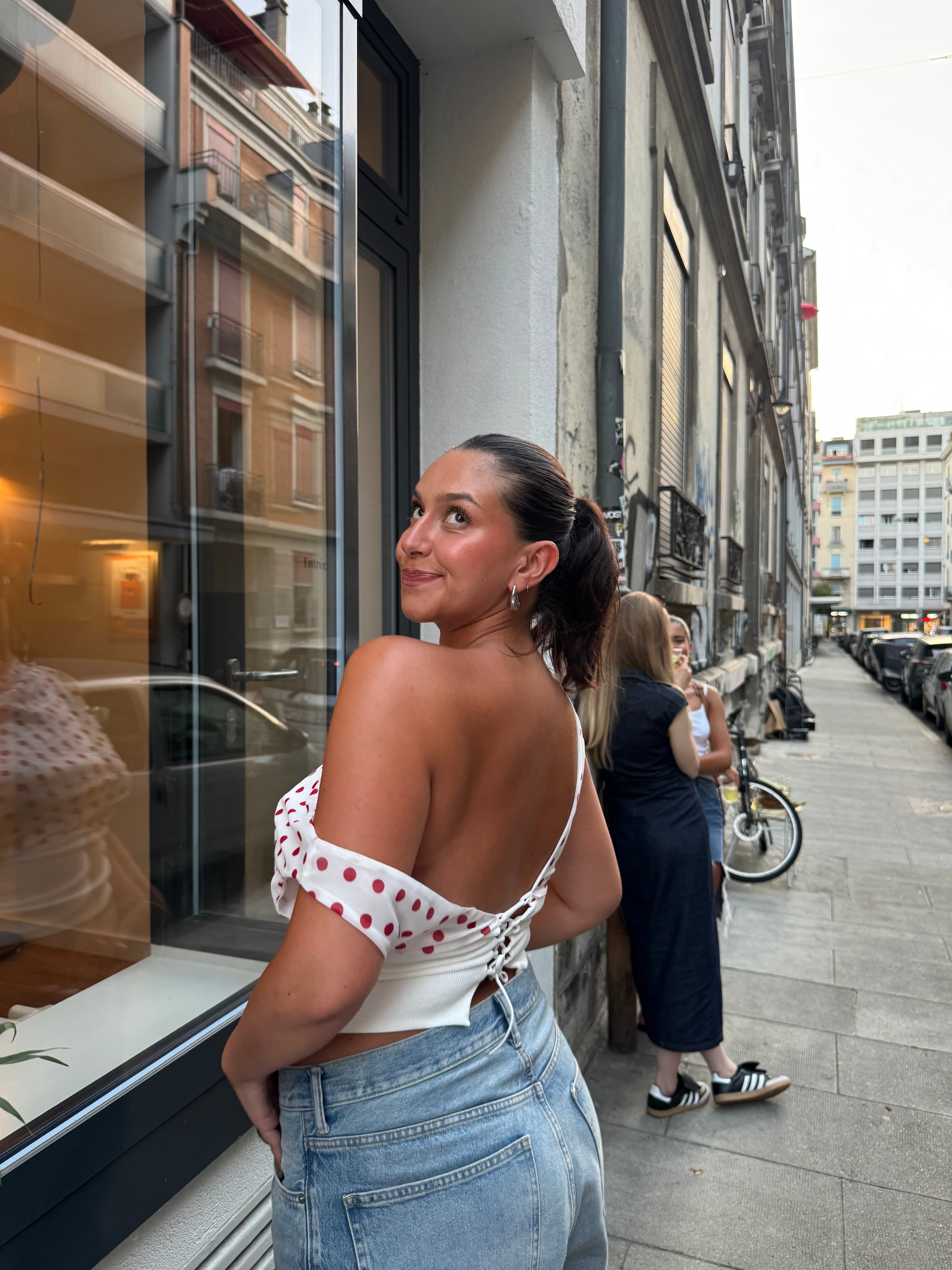 Red polka dot crop top with off-shoulder drape and white trim detail