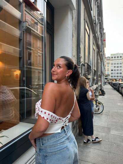 Red polka dot crop top with off-shoulder drape and white trim detail
