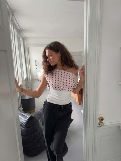 Polka dot draped crop top styled with black denim, back view