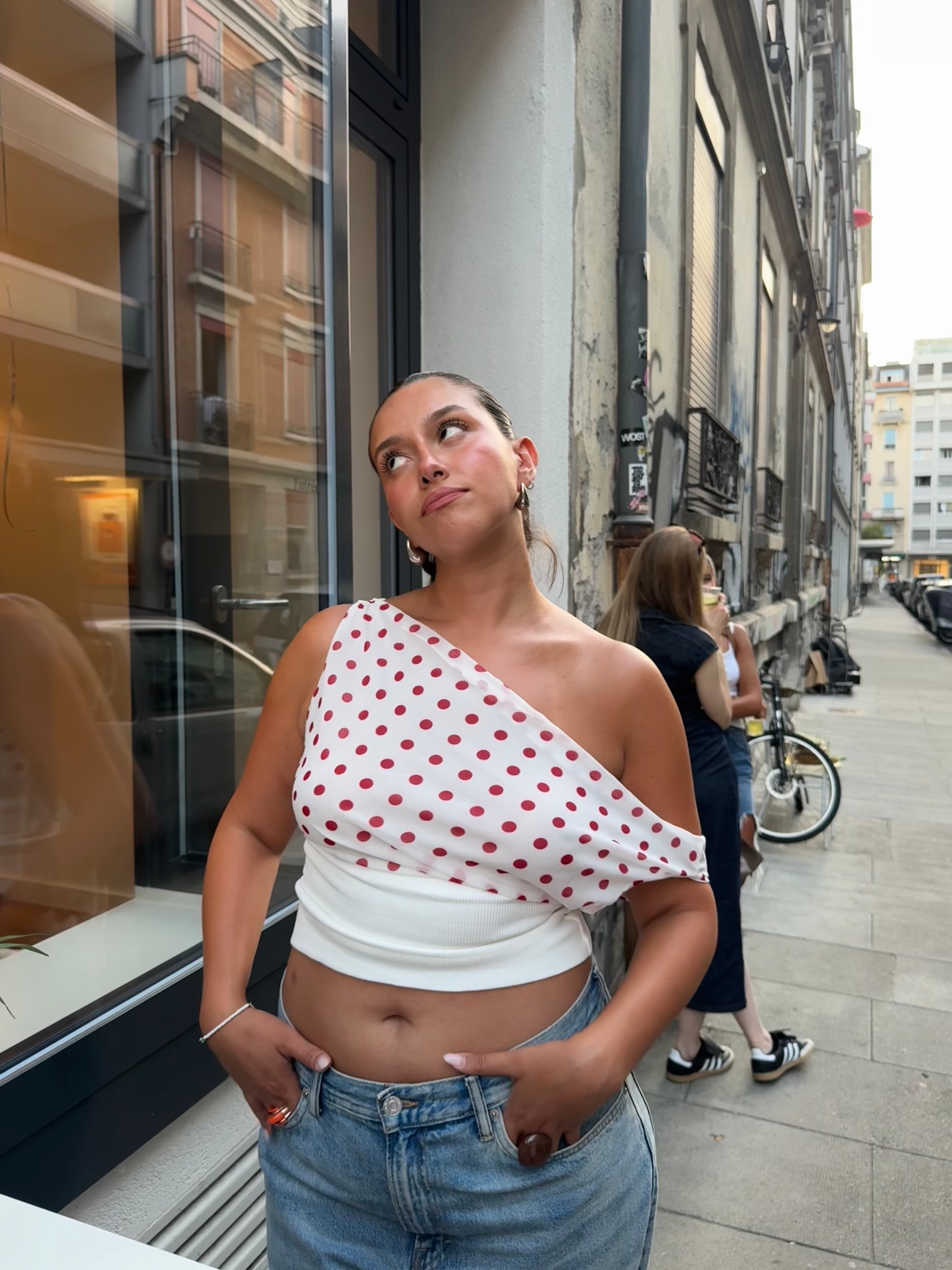 Draped polka dot crop top with asymmetrical neckline and lace-up corset back closure