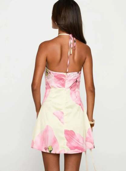 Back view of halter mini dress revealing backless tie detail and floral hem