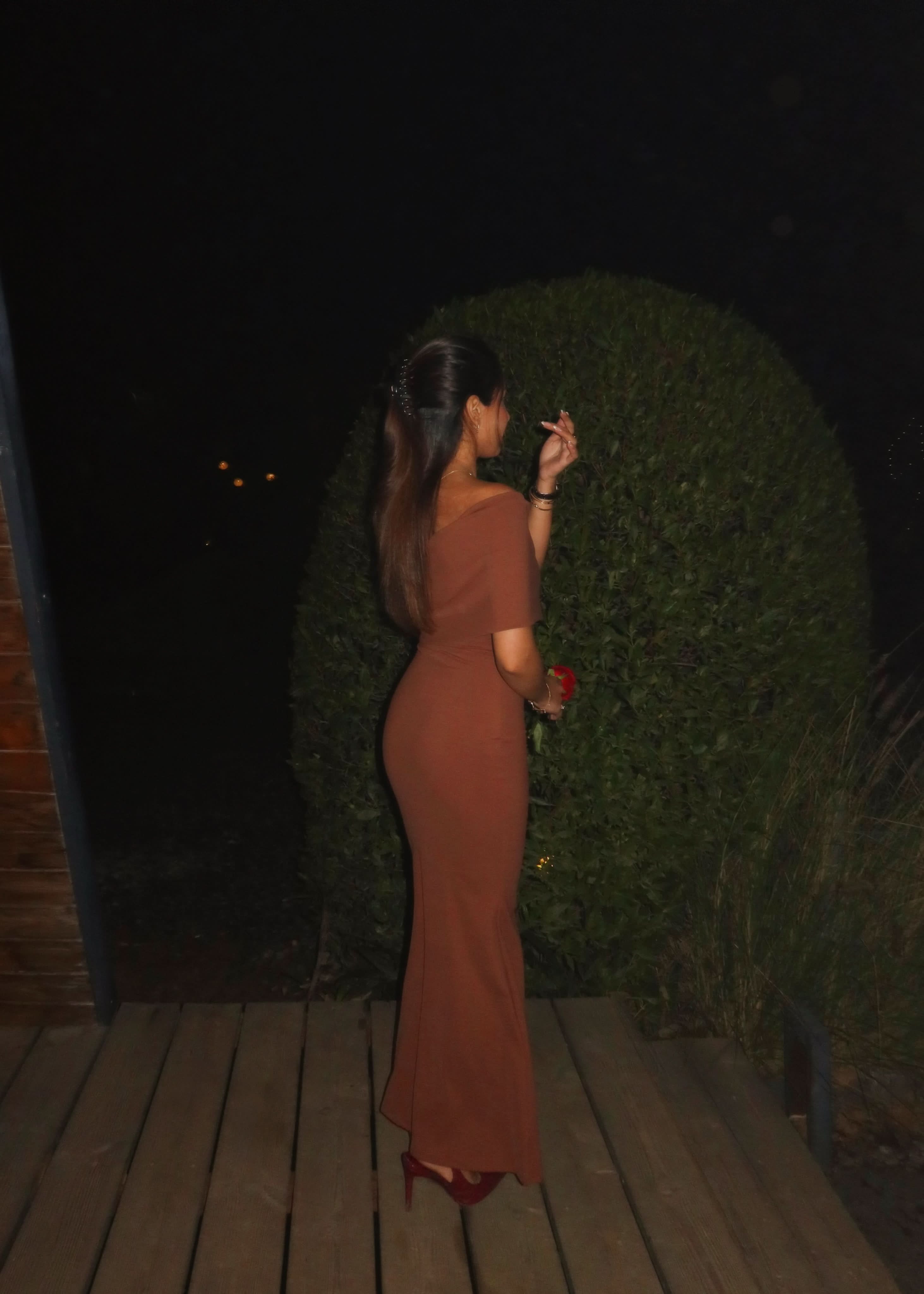 Side profile of terracotta fold-over maxi dress with flowing train detail