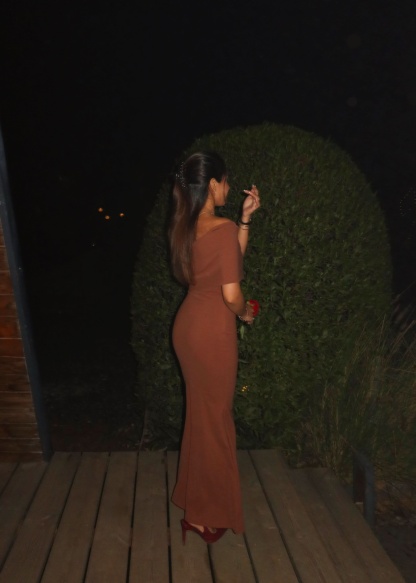 Side profile of terracotta fold-over maxi dress with flowing train detail