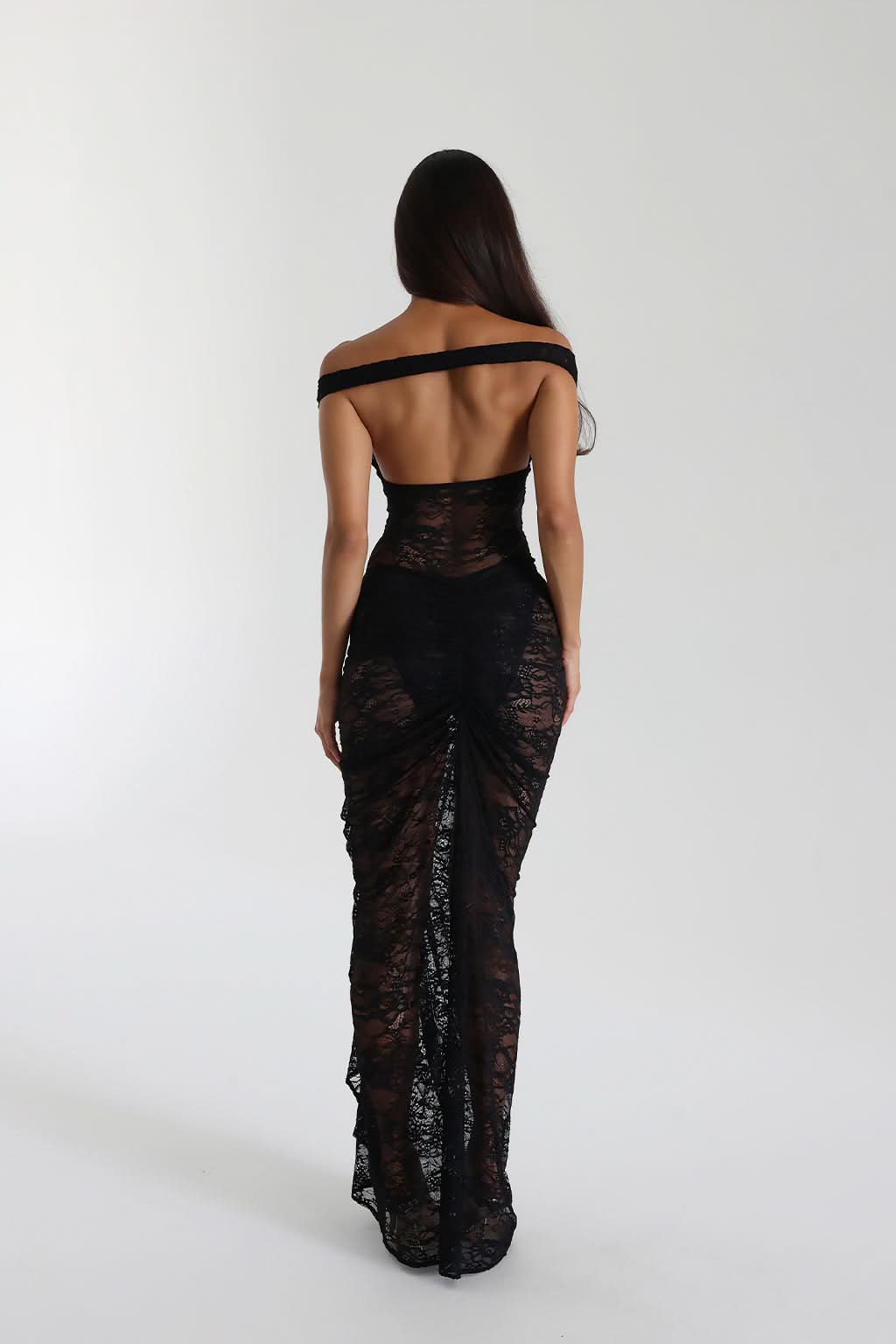 Back view of black lace maxi dress with open back and ruched side detail