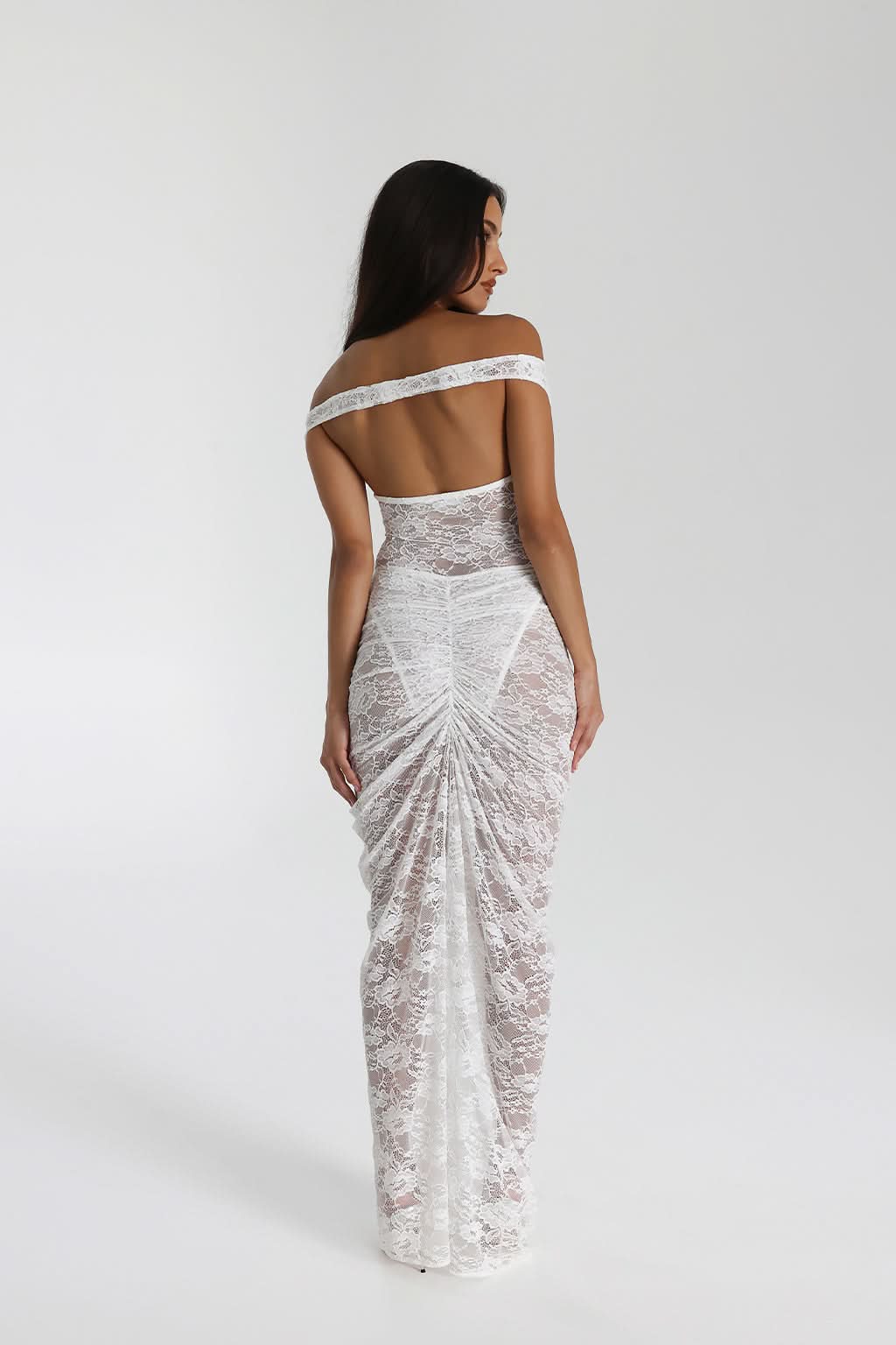 Back view of white lace maxi dress with open back and gathered ruched skirt