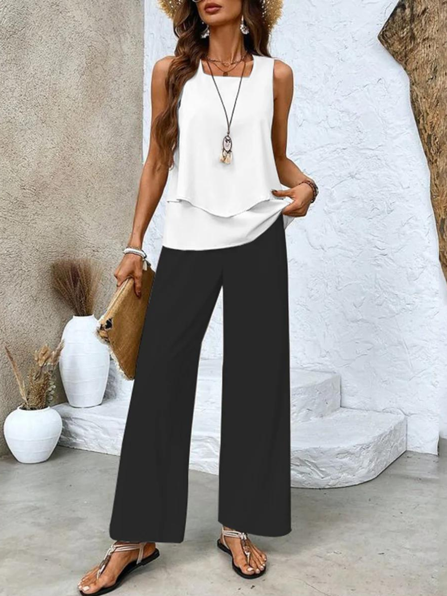White sleeveless layered top with black wide-leg pants