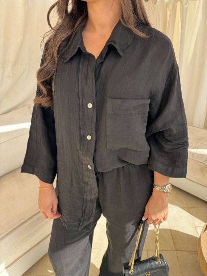 Black linen button-up shirt close-up with pocket detail