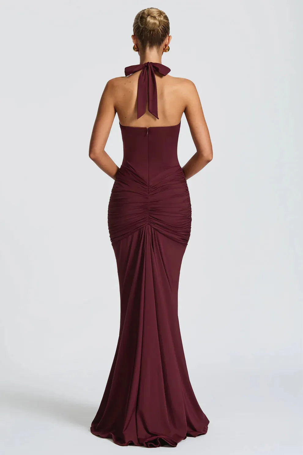 Back view of burgundy ruched maxi dress with halter tie and mermaid hem