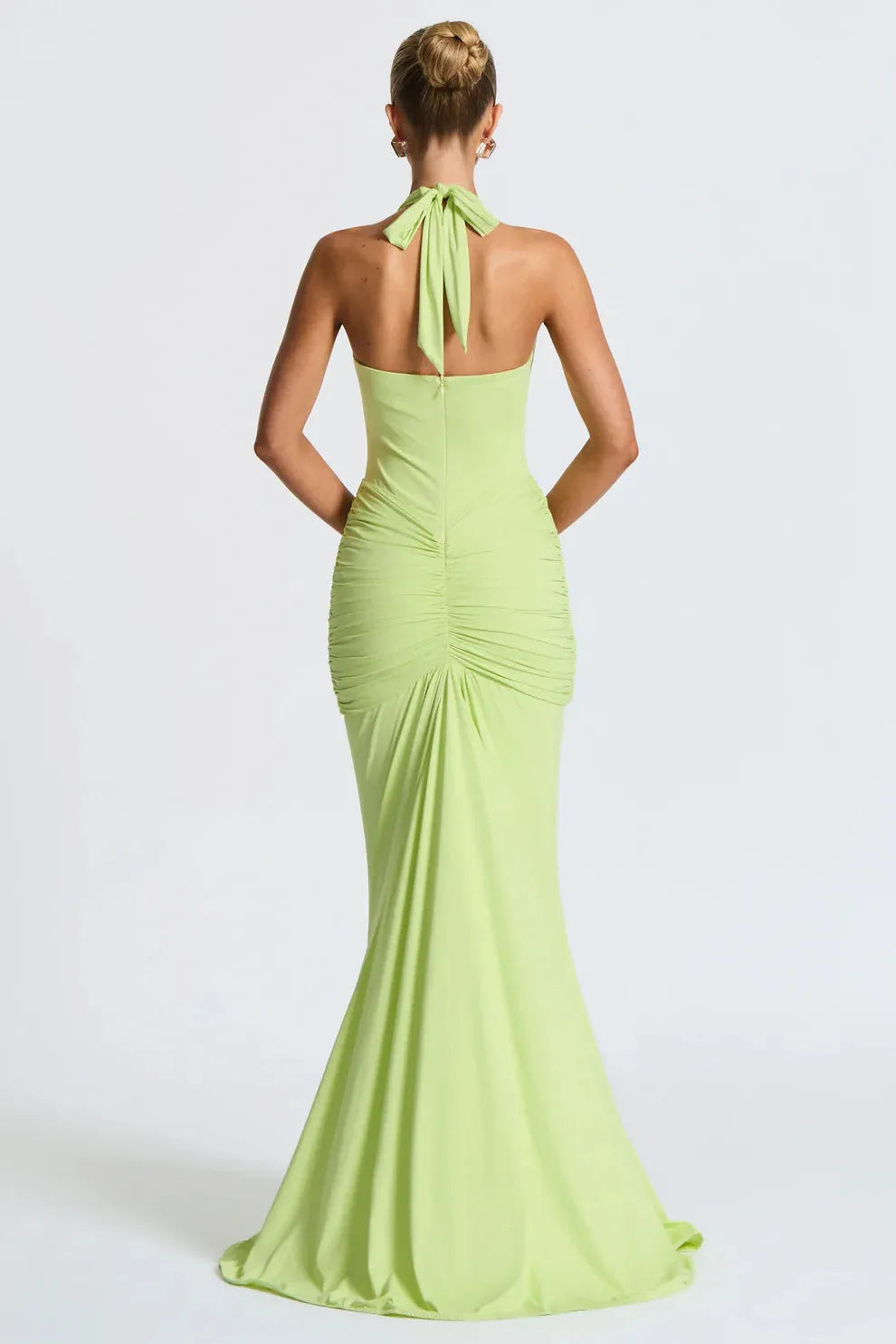 Back view of lime green halter ruched maxi dress with tied neckline and fitted silhouette