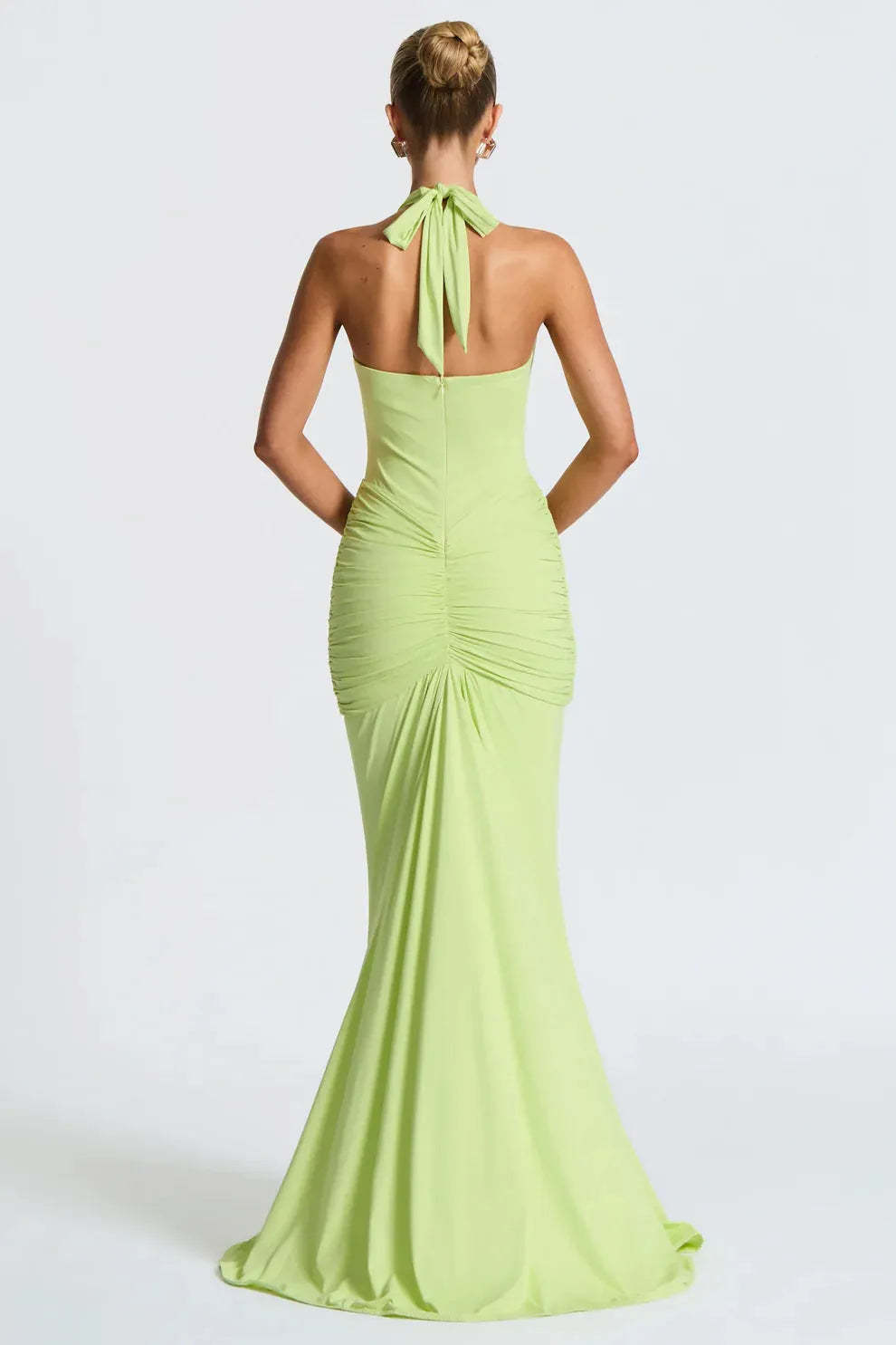 Back view of lime green halter ruched maxi dress with tied neckline and fitted silhouette