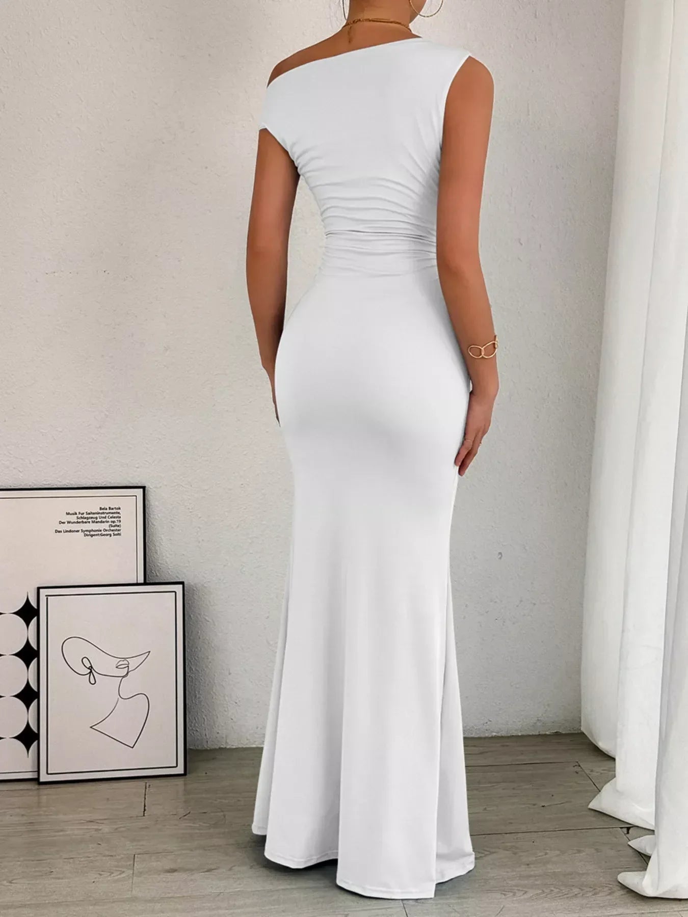 Navy ruched maxi dress with off-shoulder neckline, fitted waist, and flowing skirt