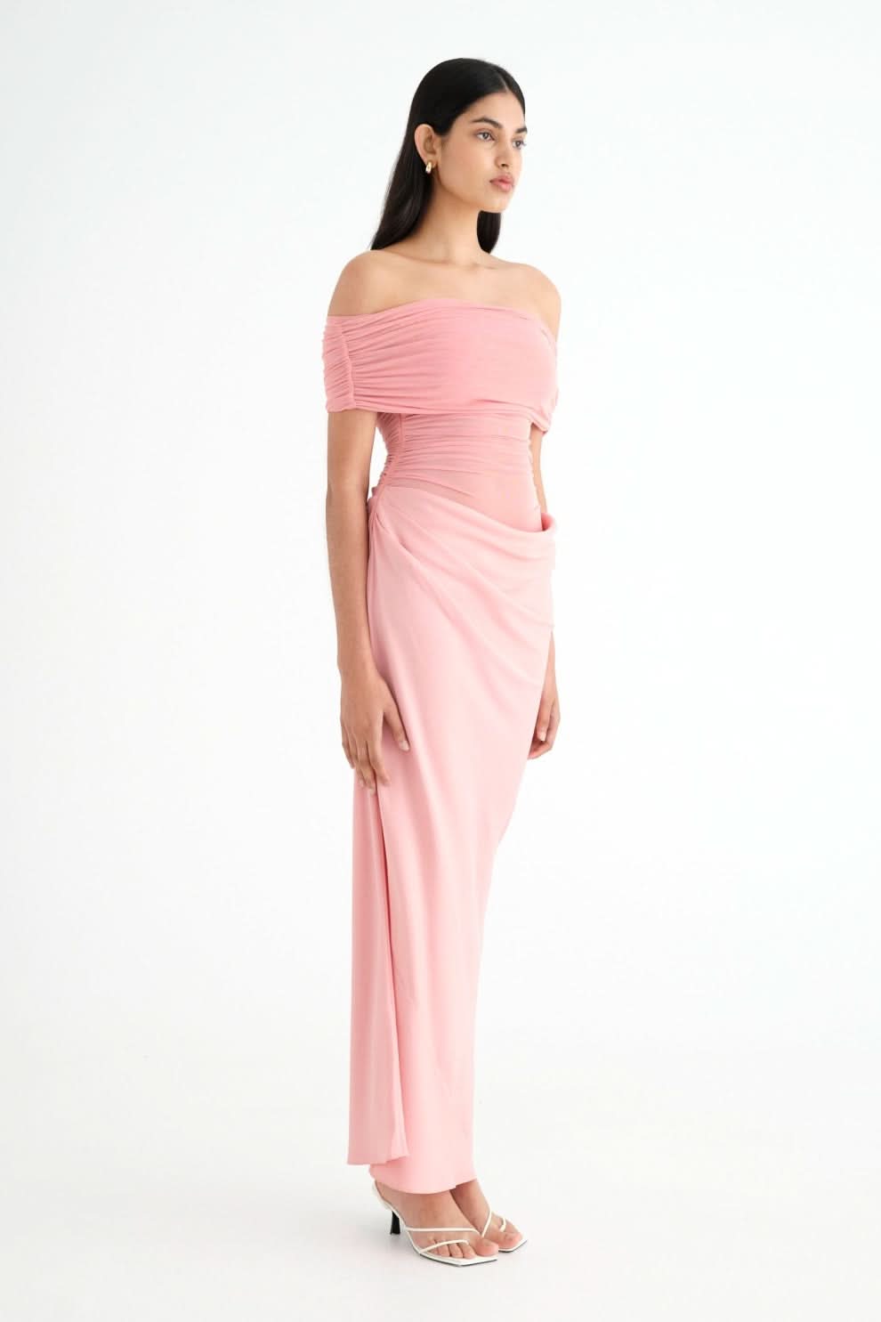 Side profile of pink ruched maxi dress with off-shoulder fit