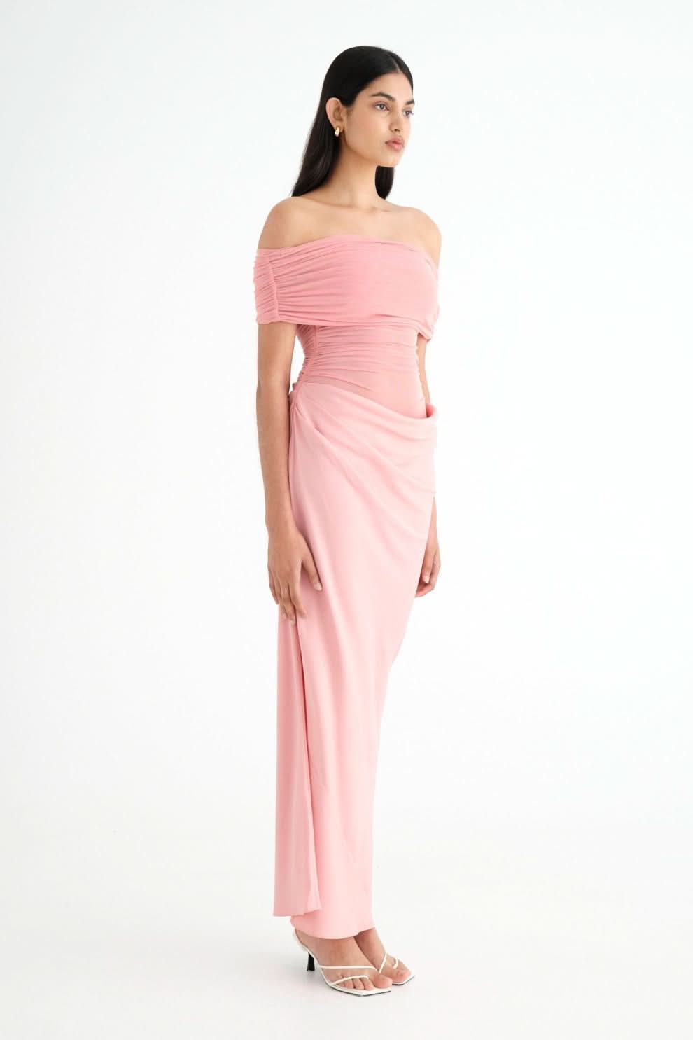 Side profile of pink ruched maxi dress with off-shoulder fit