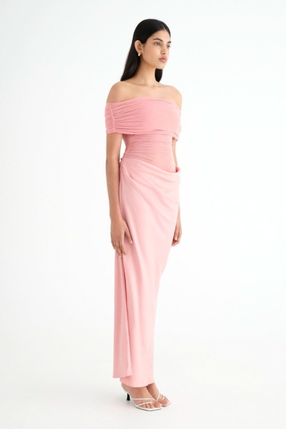 Side profile of pink ruched maxi dress with off-shoulder fit
