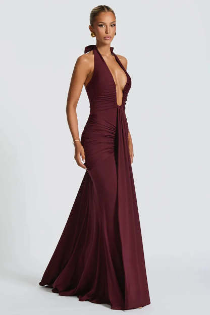 Side view of burgundy halter ruched maxi dress with fitted bodice
