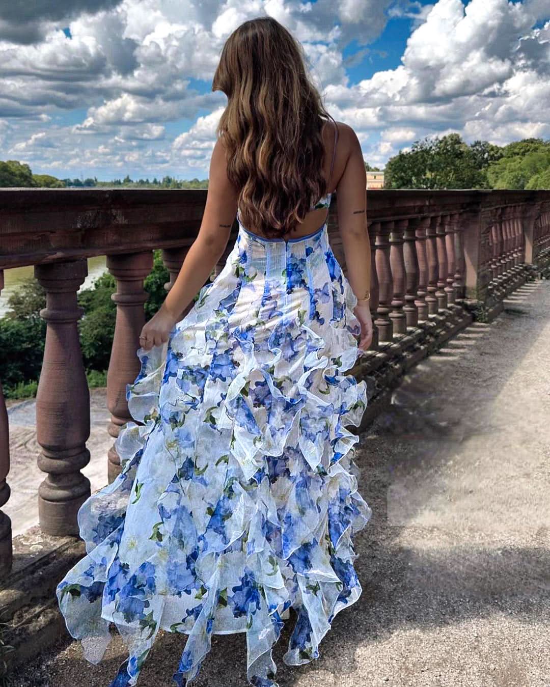 Blue floral tiered ruffle maxi dress with flowing layers and dramatic skirt movement