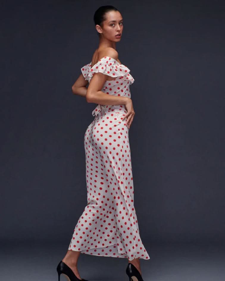 White midi dress with red polka dots, off-shoulder ruffle neckline, and fitted silhouette for women