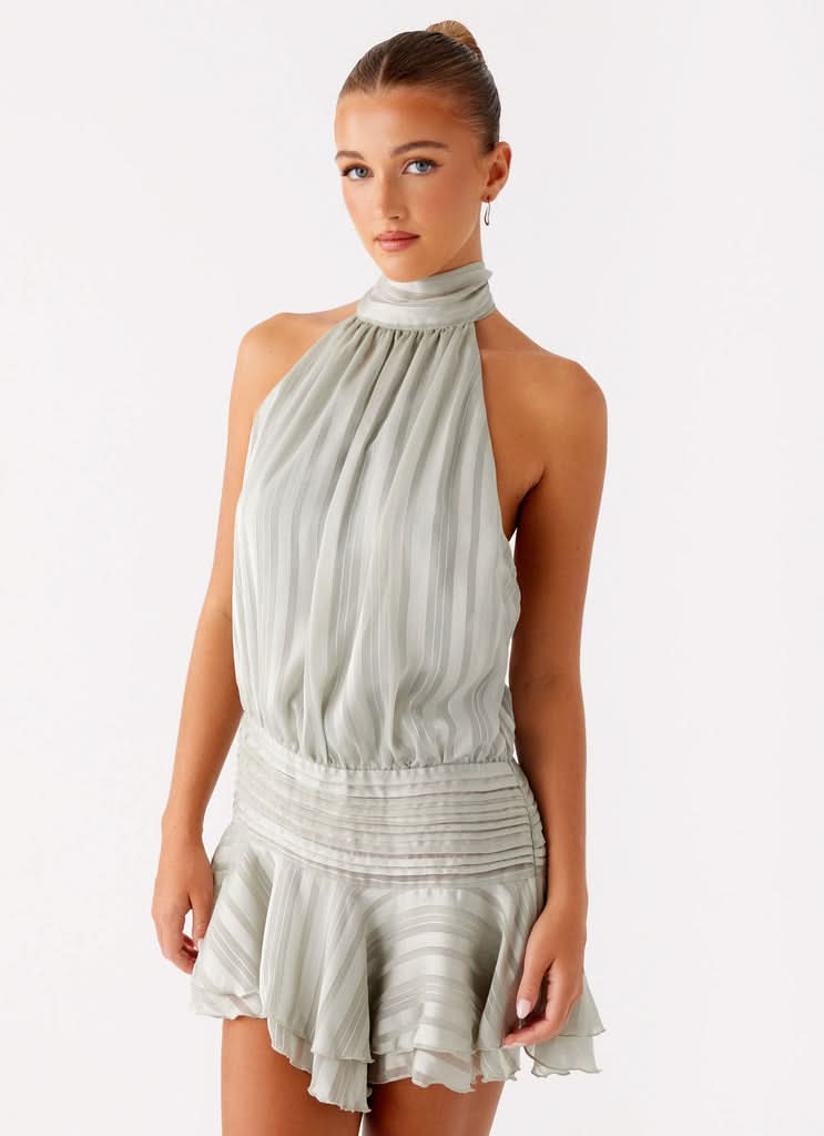 Sage green pleated halter mini dress with gathered bodice and ruffled hem