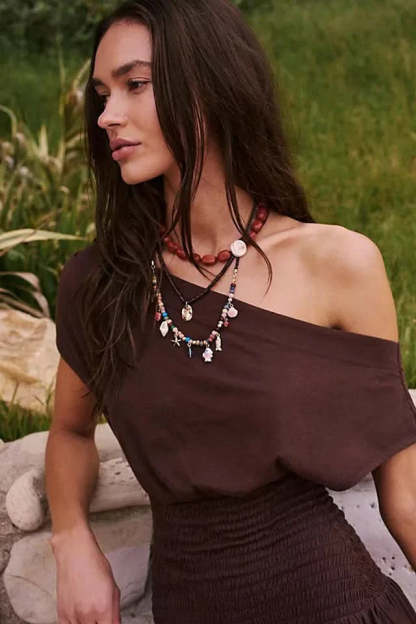 Side profile of brown off-shoulder dress with smocked waist detail